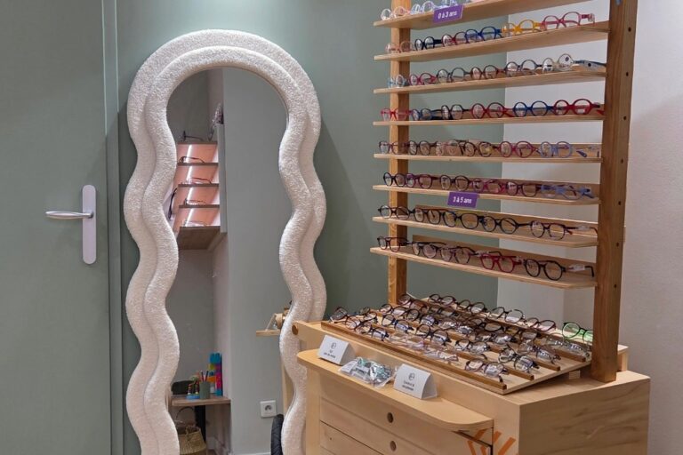 espace enfant avec étagère en bois présentant des lunettes de vue et un grand miroir